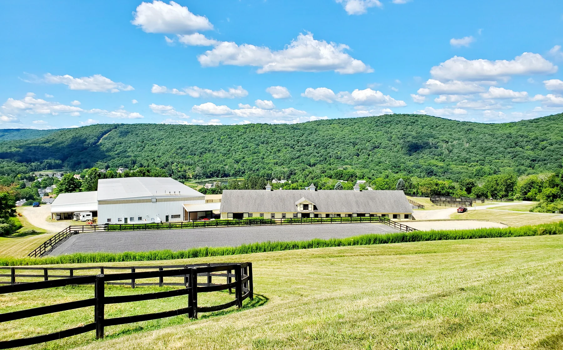 The equestrian center at Rounded Crest Farm, with the outdoor arena and the hills beyond